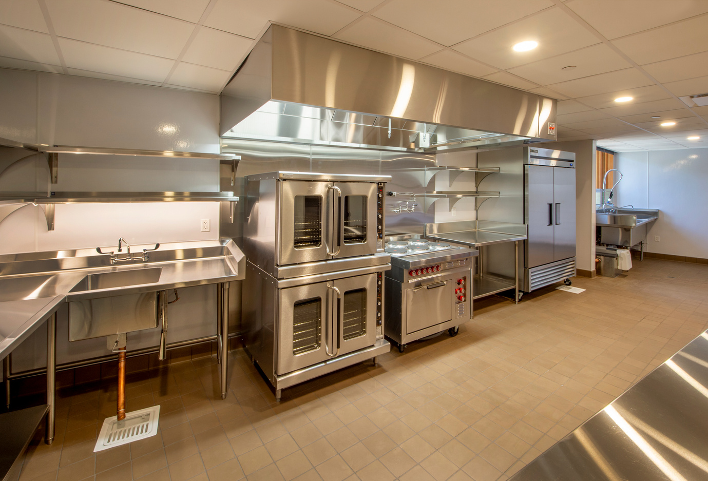 a large commercial kitchen with stainless steel appliances